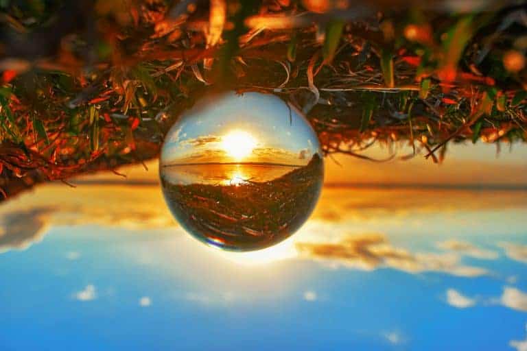 A crystal ball showing a reverse image of an upside-down landscape with the sunset