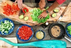 a bountiful spread of bright ingredients from red peppers cucumbers and cherry tomatoes to avocados lettuce tahini and grains