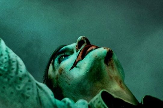 A close-up of Joaquin Phoenix as Joker, looking up
